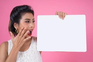 Portrait of a fashionable woman displaying a white banner photo