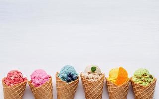 Coloridos helados en conos sobre un fondo blanco. foto
