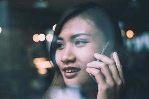 Mujer joven hablando por teléfono móvil durante el descanso en la cafetería. foto