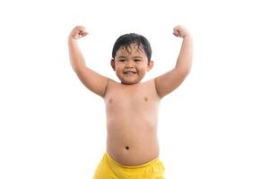 Funny little boy showing his bicep muscles isolated on white background photo