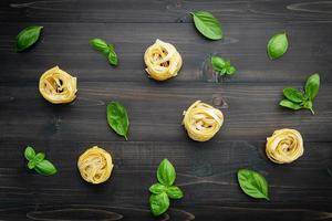 Pasta and basil on a wooden background photo