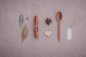 cuchara de madera con canela, anís estrellado y hojas de laurel foto