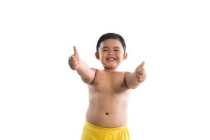 Little boy poses with thumbs up on white background photo