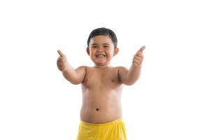 Little boy poses with thumbs up on white background photo