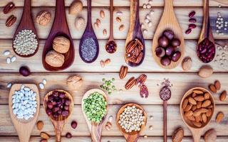 Legumes and nuts on wooden spoons photo