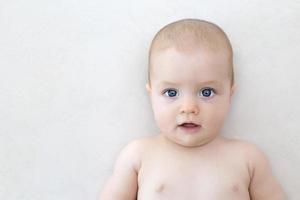 Cute baby girl lying on bed photo