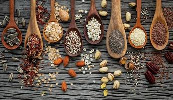 Grains and nuts in spoons on a wooden background photo
