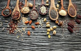 Grains and nuts in wooden spoons photo