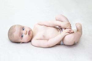 Cute baby girl lying on bed photo