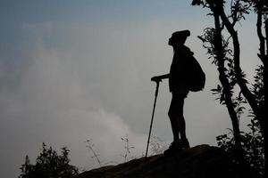 silueta de excursionista en la cima de una montaña foto