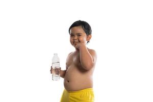 Happy little boy holding a bottle of water isolated on white background photo