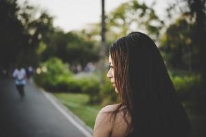 Young pretty girl sad standing in the park photo