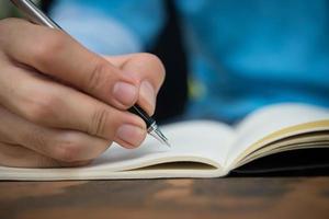 Close-up of a man writing in a notebook photo