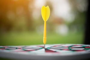 Yellow dart arrow in the center of dartboard photo