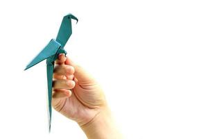 Woman's hand holding origami bird on white background photo