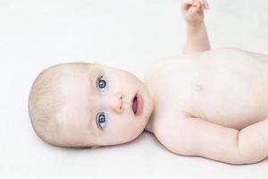 Cute baby girl lying on bed photo