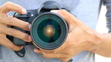 Hands holding DSLR camera photo