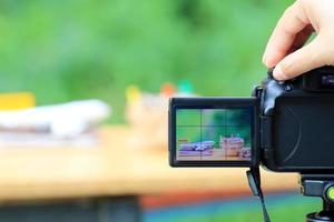 Hand with digital camera photographing desktop setup with airplanes and money sacks photo