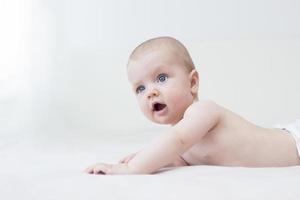 Cute baby girl lying on bed photo