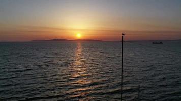 zeegezicht met een zonsondergang en een schip aan de horizon