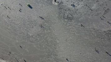 Vista aérea de la superficie helada de la bahía y gente pescando. video