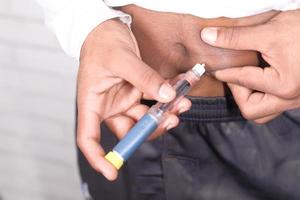 La mano del joven con pluma de insulina, close-up foto