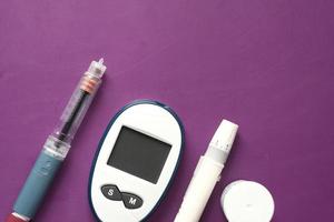 Close-up of diabetic measurement tools and pills on color background photo