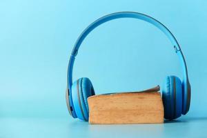 Headphones and notepad on blue background photo