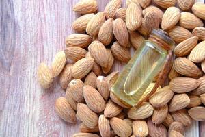 Almond oil in bottle on wooden background photo