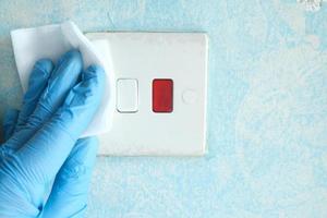 limpieza y desinfección del interruptor eléctrico con un pañuelo foto