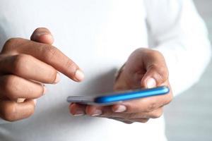 Close-up de la mano del joven con un smartphone azul foto