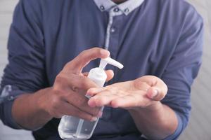 Man using sanitizer liquid for preventing corona virus photo