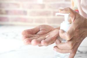 Primer plano de una mujer mayor con gel desinfectante de manos para prevenir el virus
