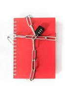 Red notebook chained with combination lock on white background photo