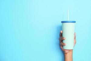 Hand holding reusable eco coffee cup close-up photo