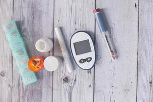 Top view of diabetic measurement tools and pills on color background photo