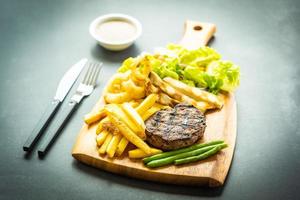 Filete de ternera a la parrilla con salsa de papas fritas y verduras frescas foto