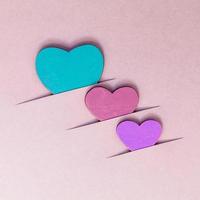 Wooden hearts on cardboard background photo