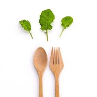 hojas verdes y utensilios de madera. foto