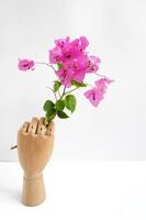 Wooden hand holding flowers photo