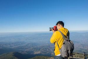 Fotógrafo tomando fotos en la cima de una montaña en Tailandia