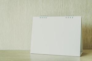 Blank white calendar on wooden background photo