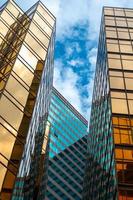 View looking up at skyscrapers with cloudy blue sky photo