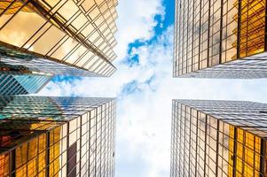 View looking up at skyscrapers with cloudy blue sky photo