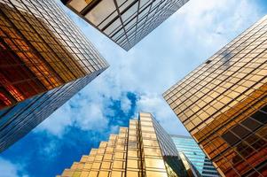 View looking up at skyscrapers with cloudy blue sky photo