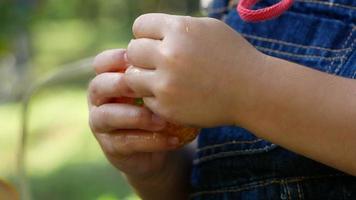 Cute little girl peeling oranges and eating with happiness outside video