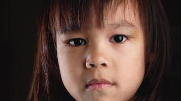 Close-up portrait of cute little girl upset sleepy looking at camera video