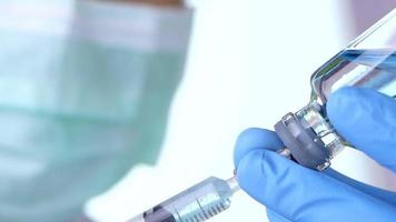 Close up doctor's hand filling a syringe with vaccine at the hospital. video