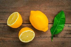 Fresh lemons on a rustic wooden background photo