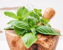 Fresh herbs in a wooden mortar photo